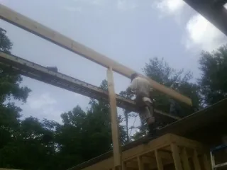 Carpenter setting a ridge beam over a new addition frame — Ice Dam Removal by Roofing Brothers in Custar