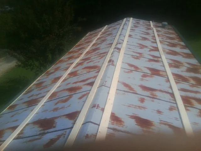 Rusted metal roof panels with new wood purlins before replacement — Storm Damage Roof Repair in Custar by Roofing Brothers